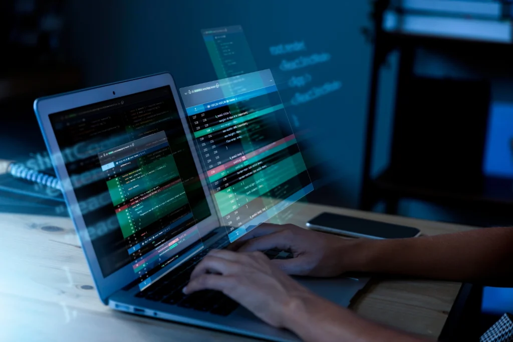 Pessoa digitando em um laptop com códigos projetados no ar, representando o uso de blockchain para proteção de direitos autorais na era da inteligência artificial.