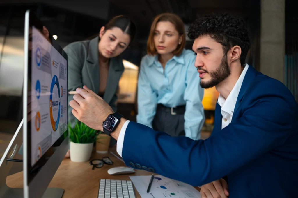 Pessoas analisando gráficos financeiros, representando a análise de dados para definição do perfil ideal de cliente.