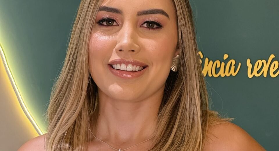 Thainá Palkoski, especialista em Customer Success e liderança de times, sorrindo em ambiente profissional.