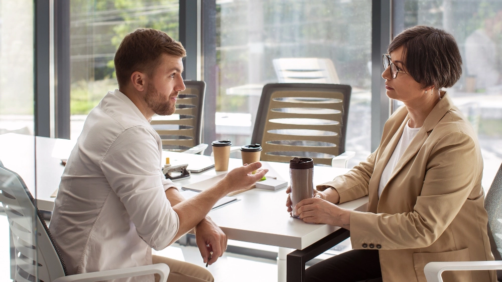 Dois executivos conversando e construindo rapport em ambiente corporativo